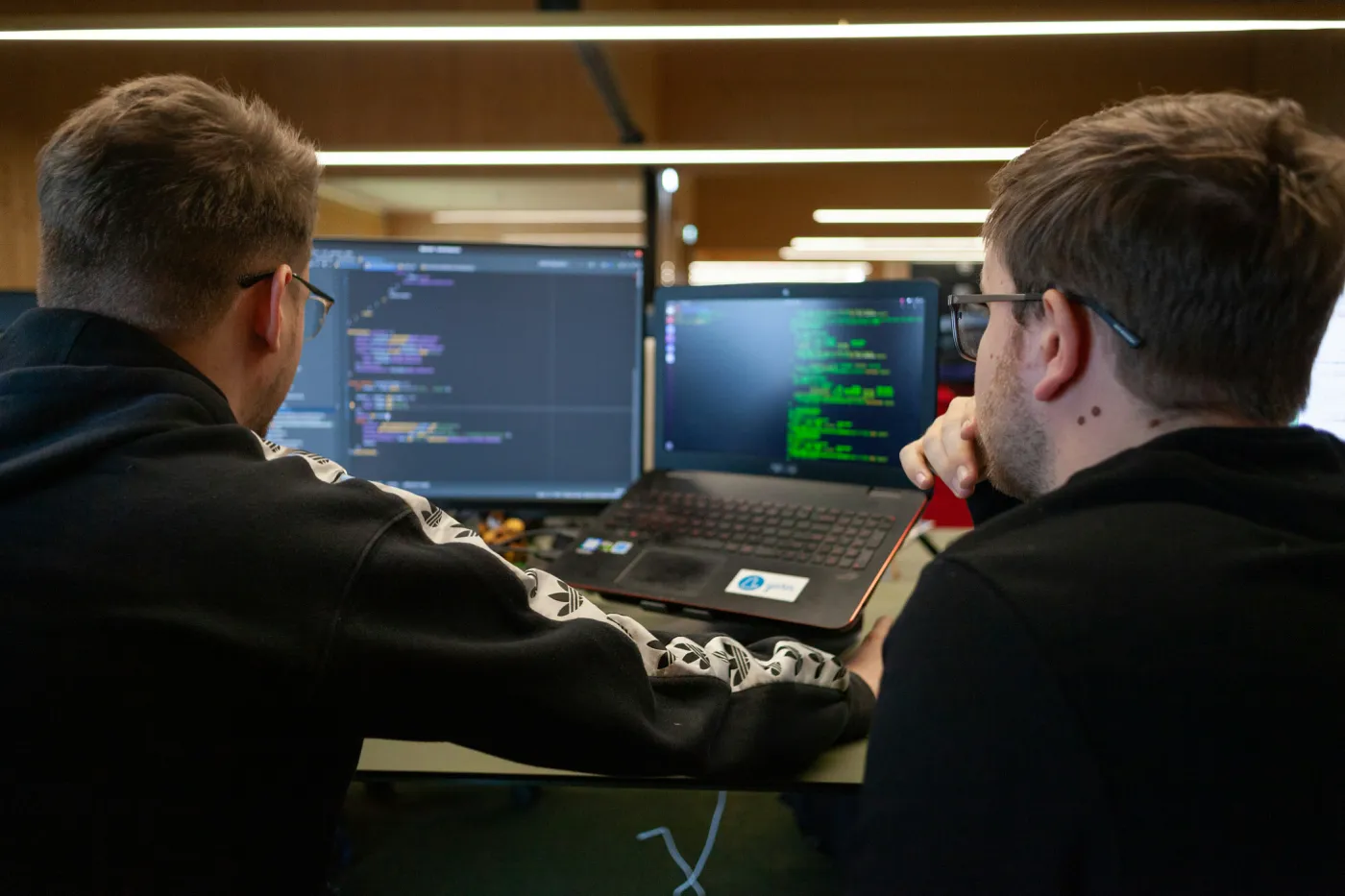 Two Sage ISG security engineers reviewing code and alerts together